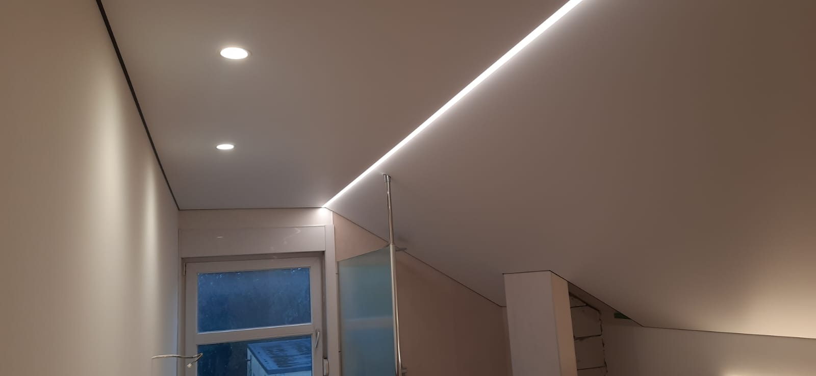 Realisatie van een strak spanplafond met inbouwspots, zwarte randafwerking en indirecte ledverlichting